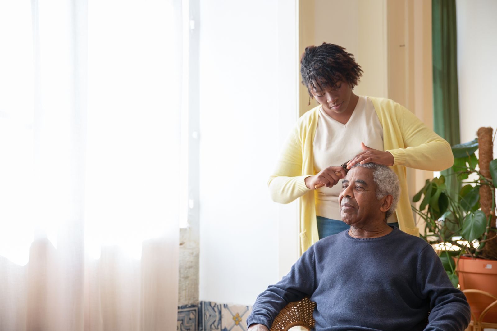 A caregiver holding an older woman's hands